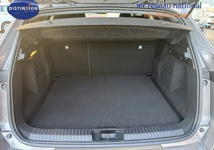 Coffre ouvert vu de l'arrière d'une Renault Symbioz gris Cassiopée Métal, espace de chargement spacieux et propre.