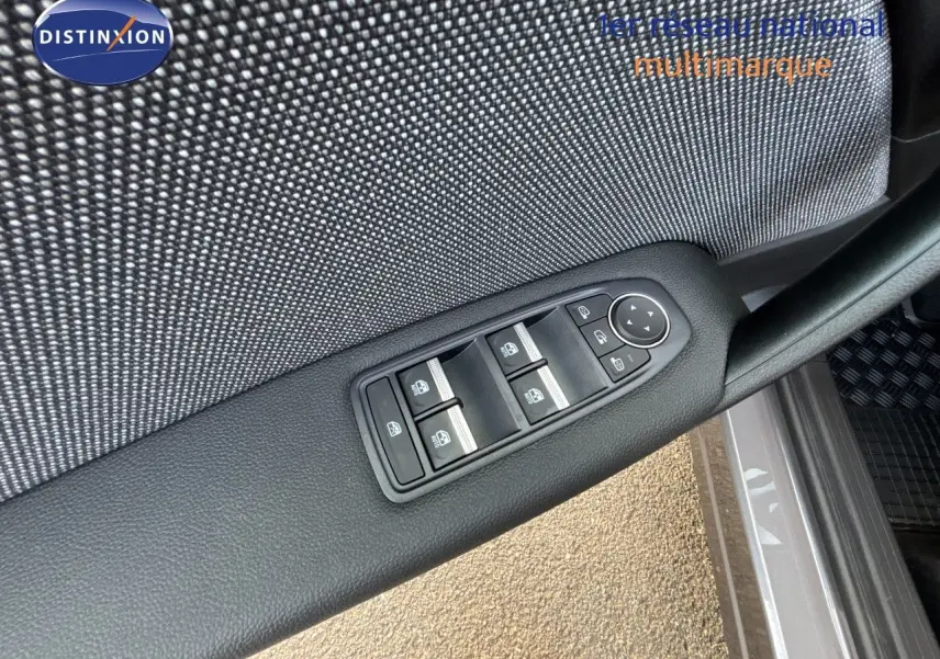 Gros plan sur les commandes des vitres électriques côté conducteur du Renault Symbioz gris Cassiopée métal, intérieur tissu.
