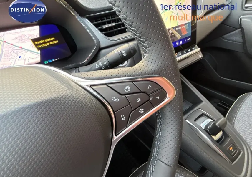 Gros plan sur le volant et la console centrale de la Renault Symbioz gris cassiopée, avec écran tactile et commandes intégrées.