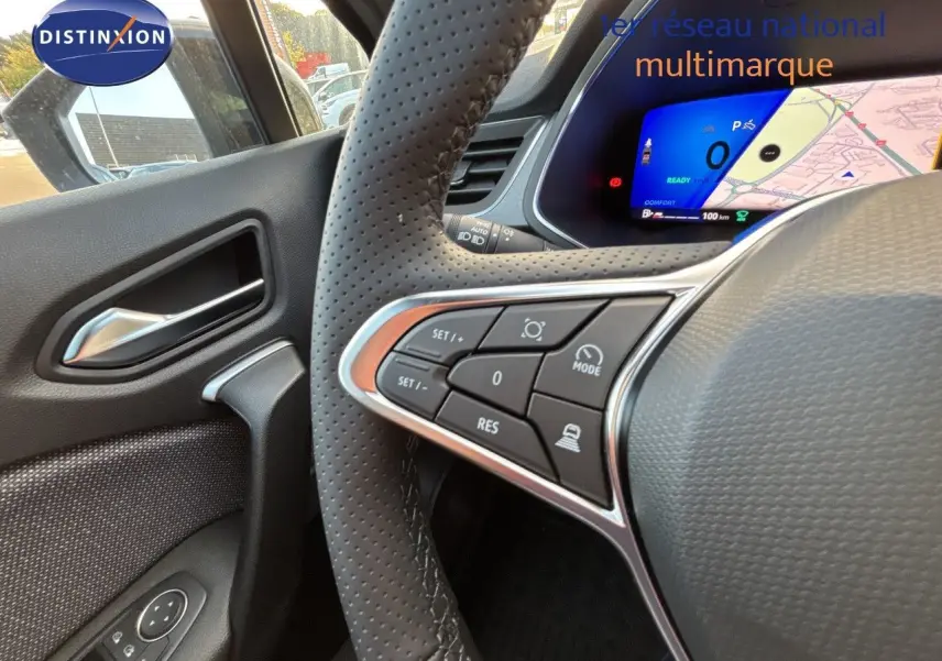 Vue intérieure côté gauche du volant perforé d'une Renault Symbioz gris cassiopée, avec commandes au volant et tableau de bord digital.