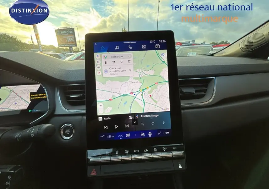 Vue intérieure centrée sur l’écran tactile vertical du tableau de bord du Renault Symbioz gris Cassiopée, avec commandes climatisation visibles.