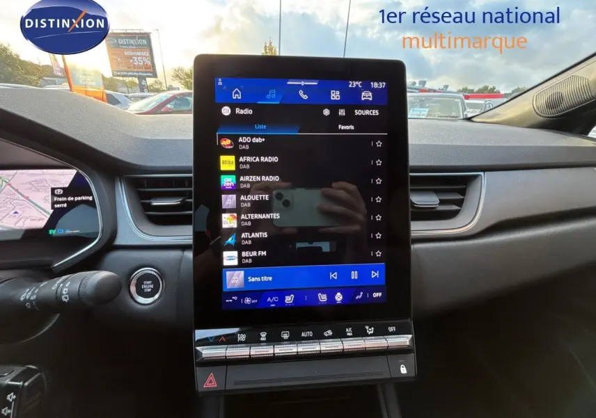 Vue intérieure centrée sur l'écran tactile vertical du tableau de bord du Renault Symbioz gris, avec commandes climatisation visibles.