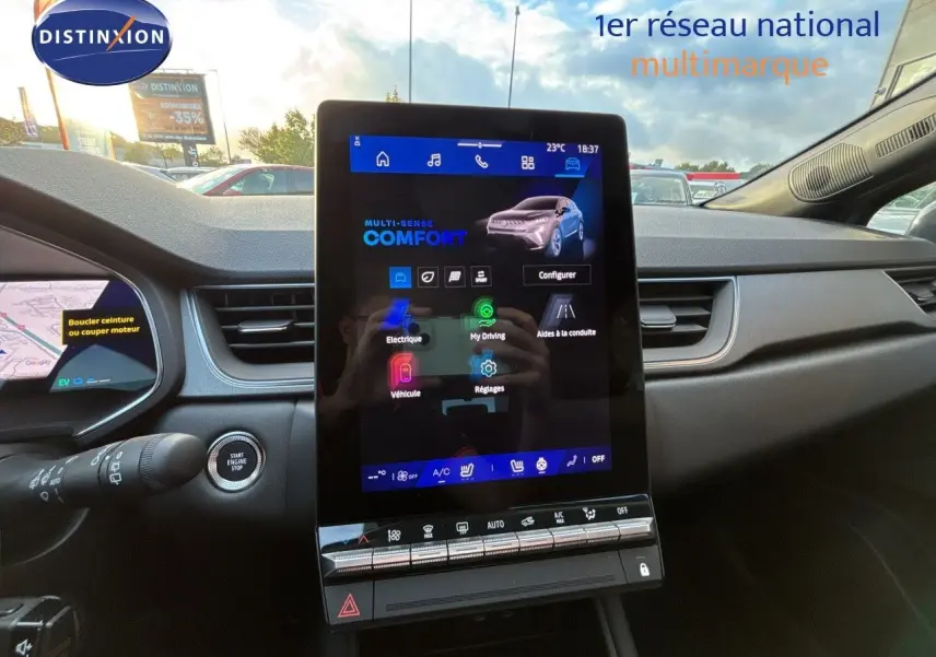Vue intérieure centrée sur l'écran tactile vertical du tableau de bord du Renault Symbioz gris, avec commandes climatisation visibles.