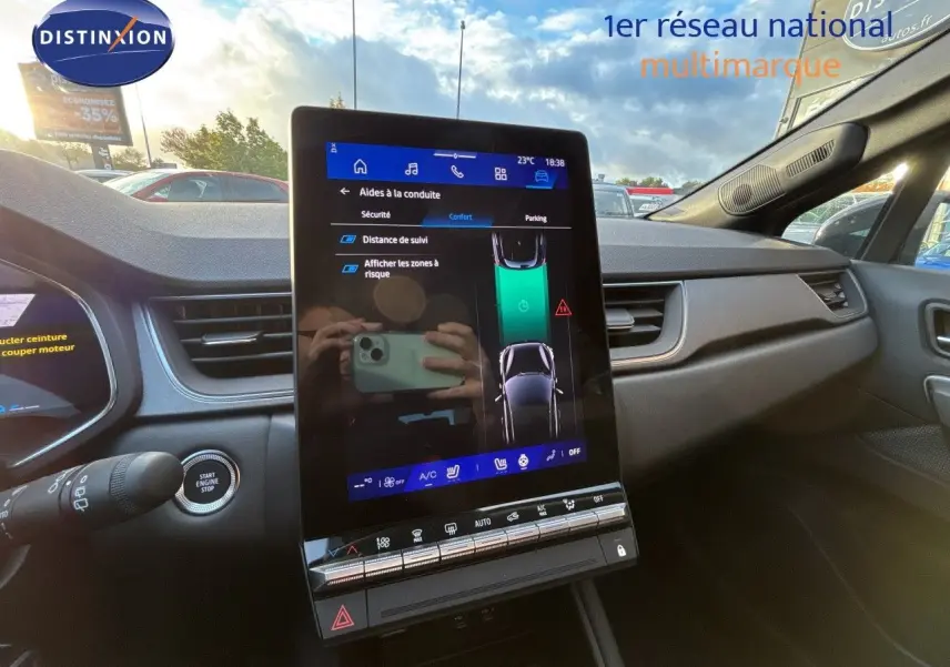 Vue intérieure centrée sur l’écran tactile vertical du tableau de bord du Renault Symbioz gris cassiopée, avec commandes visibles.