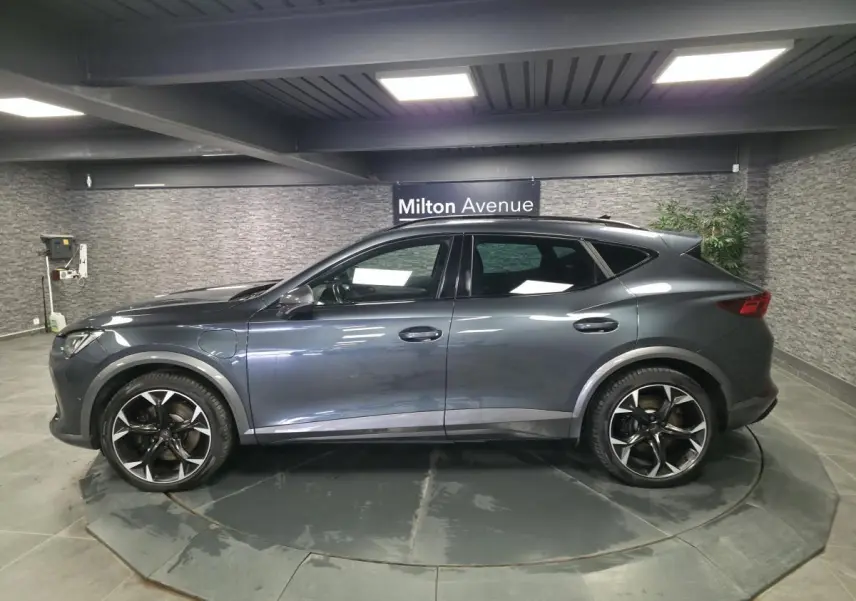 Vue de profil côté gauche du CUPRA Formentor gris, soulignant ses jantes alliage noires et détails de carrosserie sportifs.