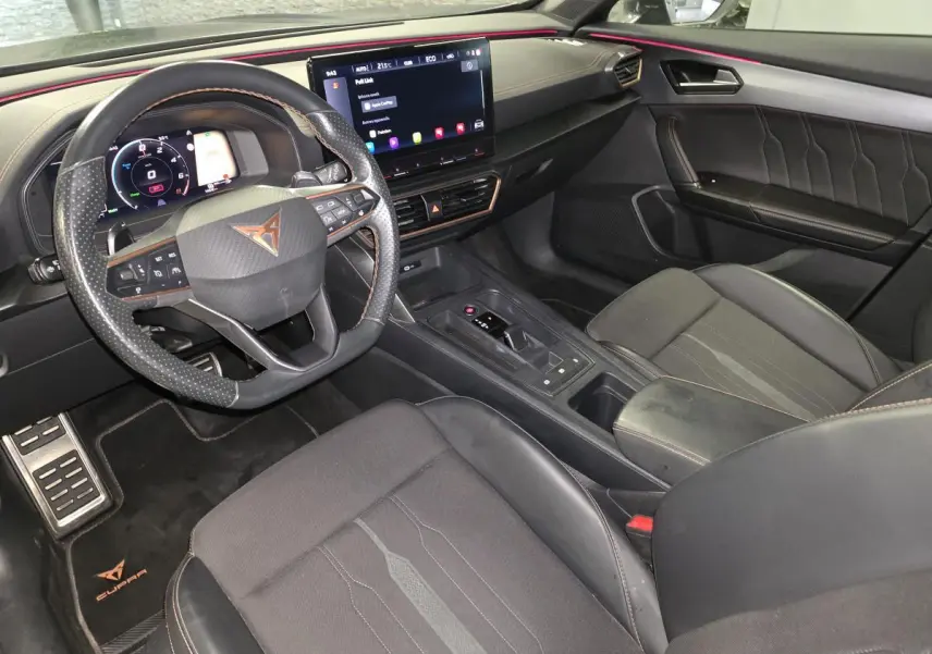 Vue intérieure côté conducteur du Cupra Formentor 2024, tableau de bord noir avec surpiqûres cuivre et écran tactile central.