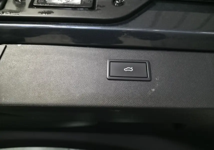 Bouton d'ouverture électrique du hayon sur la garniture intérieure noire d'un CUPRA Formentor gris.