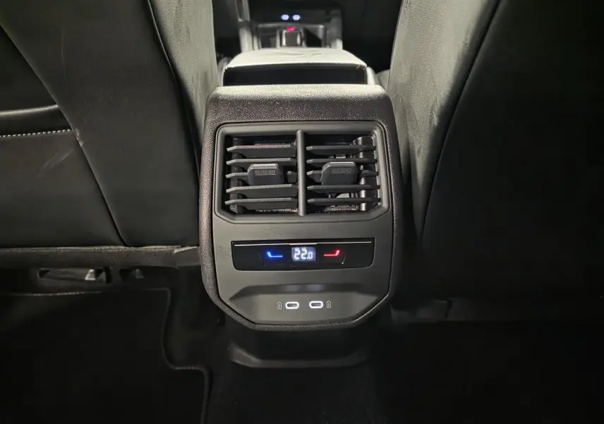Vue rapprochée de la console arrière noire du CUPRA Formentor gris avec commandes climatisation et prises USB-C éclairées.