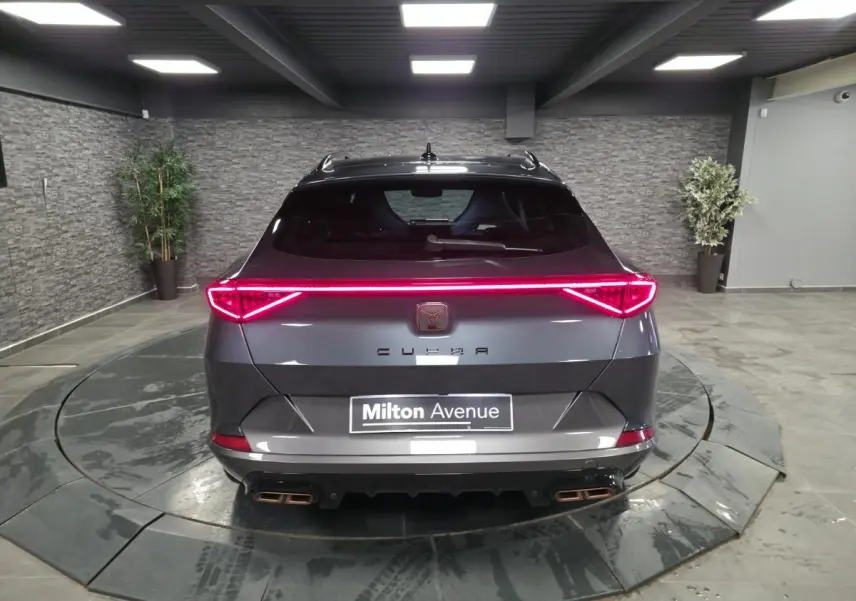 Vue arrière d'un CUPRA Formentor gris 2024 avec bandeau lumineux LED et double sortie d'échappement Copper stylisée.