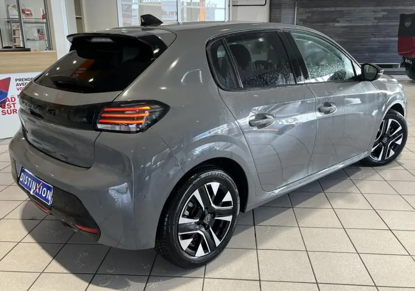Peugeot 208 gris clair sélénium vue 3/4 arrière droit, feux arrière LED 3 griffes et jantes alliage diamantées.