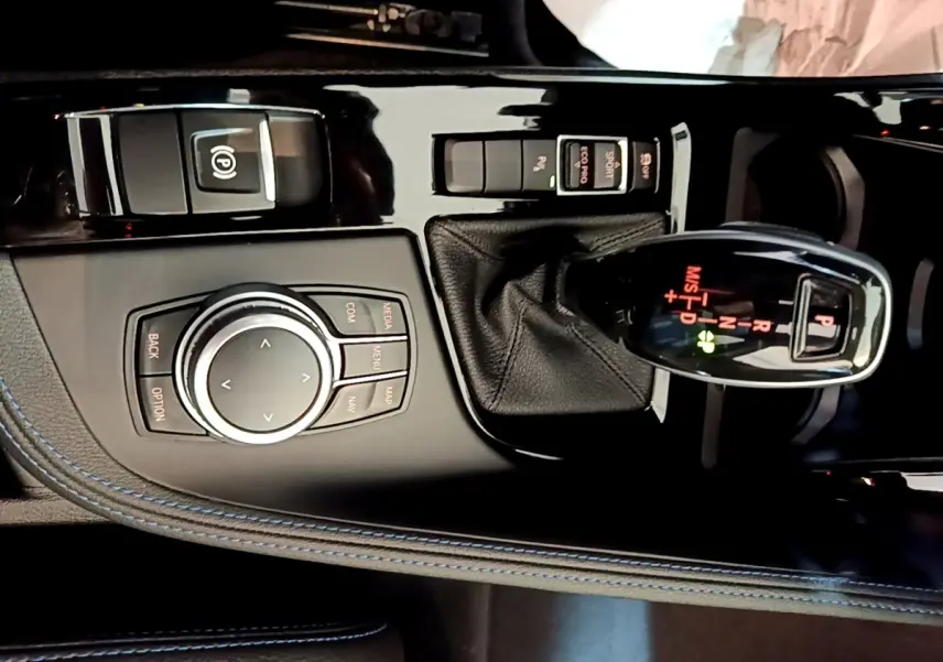 Gros plan sur la console centrale noire du BMW X1 sDrive18i M Sport 2022, avec levier de vitesses et molette de contrôle.