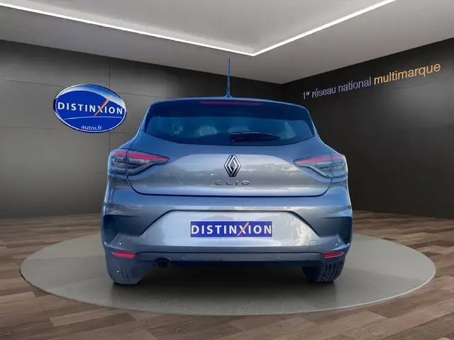 Vue arrière d'une Renault Clio V gris schiste 2025 avec feux arrière Full LED et logo distinctif sur fond showroom