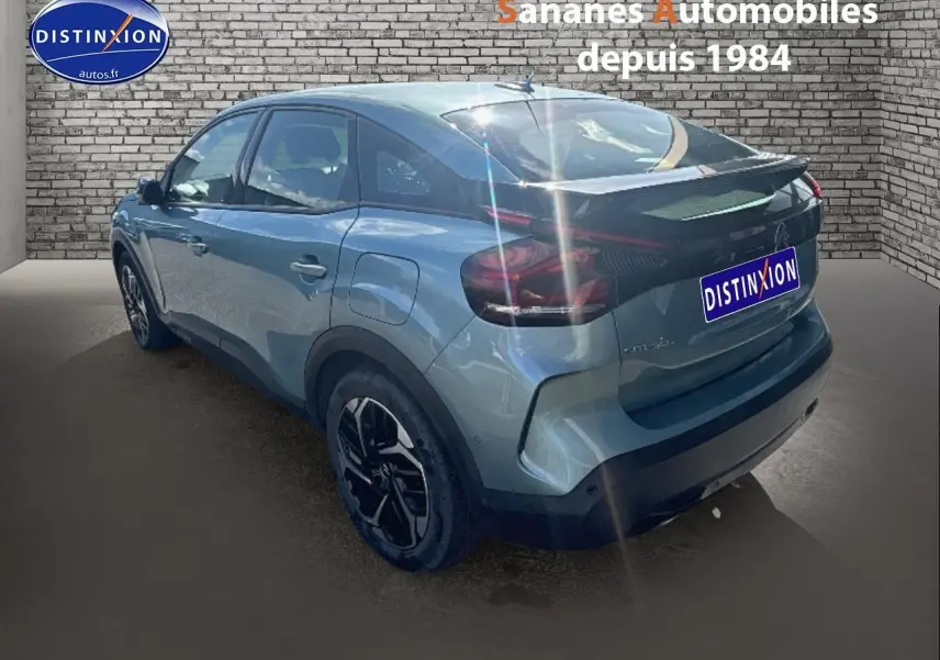 Vue 3/4 arrière droite d'une Citroën C4 bleu clair métallisé avec jantes alliage noires et toit noir.