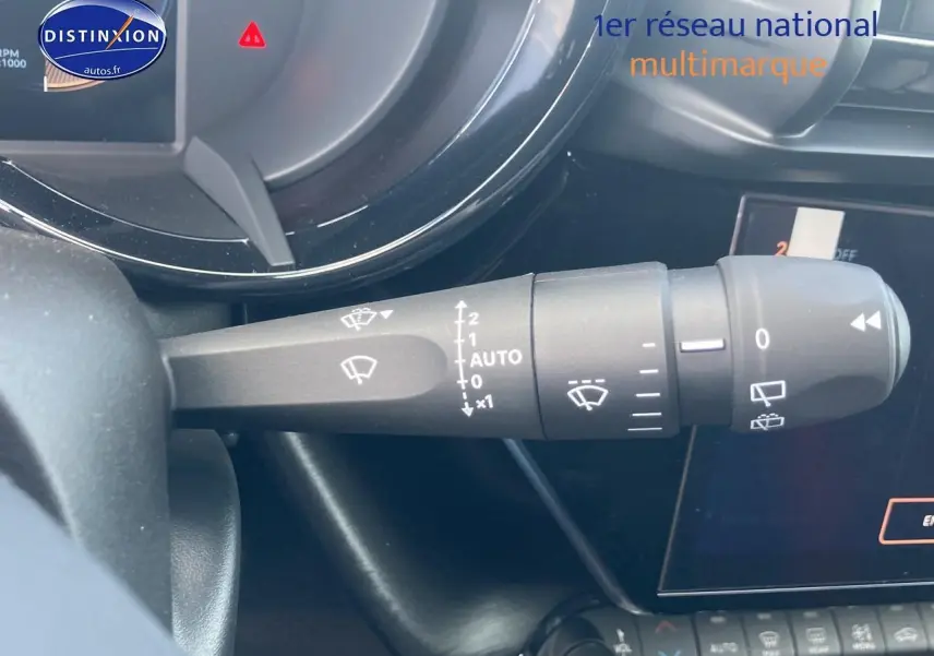 Gros plan sur la commande des essuie-glaces à gauche du volant dans l’habitacle d’une Alfa Romeo Junior gris 2026.