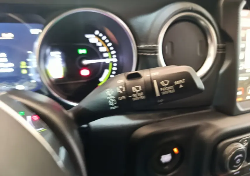 Gros plan sur la commande d’essuie-glace et le tableau de bord du Jeep Wrangler 2022, intérieur noir.