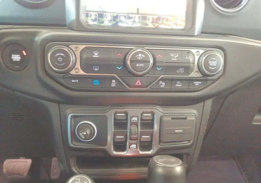 Vue rapprochée du tableau de bord central et des commandes de climatisation du Jeep Wrangler gris foncé 2022.