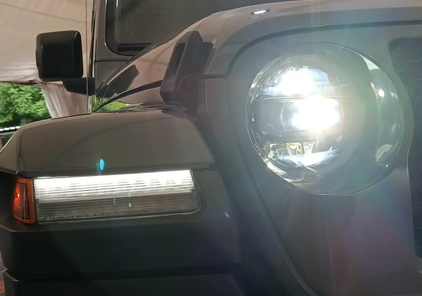 Gros plan sur l'avant droit gris foncé du Jeep Wrangler 2022 avec phare LED allumé et clignotant latéral visible.