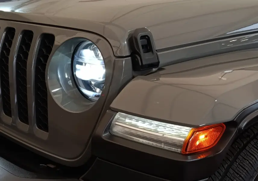 Gros plan sur l’avant droit gris foncé du Jeep Wrangler 2022, phare LED allumé et clignotant orange visible.