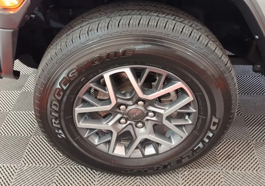 Gros plan sur la roue avant droite gris foncé du Jeep Wrangler 2022 avec jante aluminium et pneu Bridgestone.