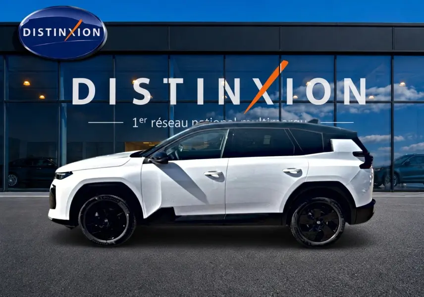 Profil côté gauche du Citroën C5 Aircross blanc et noir avec jantes alliage noires devant une vitrine Distinxion.