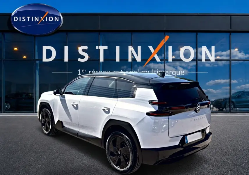 Vue 3/4 arrière droite du Citroën C5 Aircross blanc et noir avec jantes alliage 19 pouces devant un showroom Distinxion.