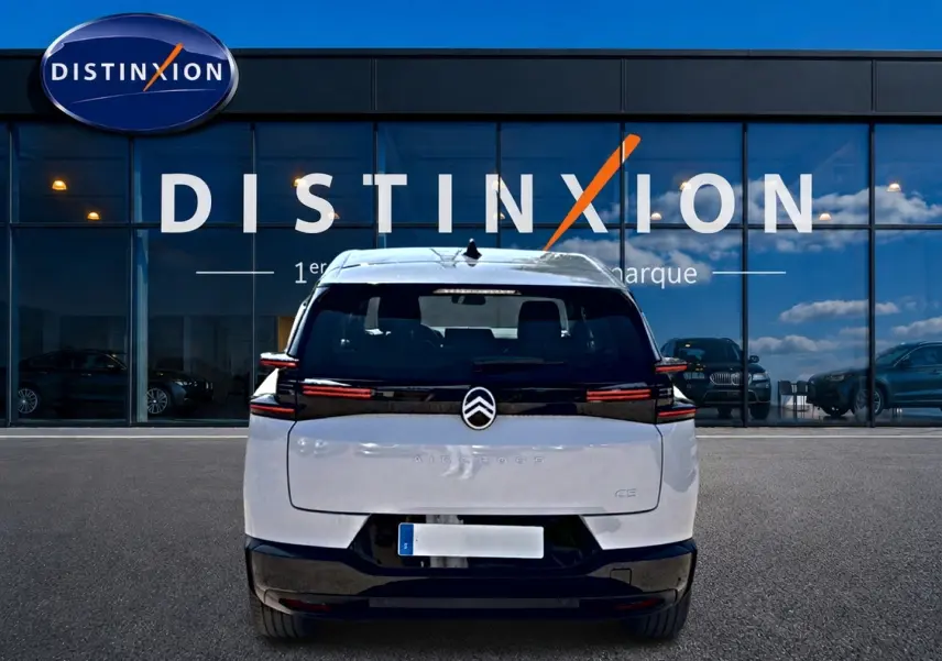 Vue arrière d'un Citroën C5 Aircross blanc et noir avec feux LED horizontaux, devant une vitrine Distinxion.