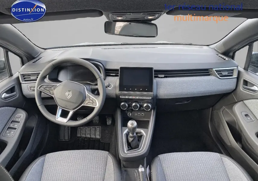 Vue intérieure avant de la Renault Clio V gris rafale, volant multifonction et boîte manuelle au centre.