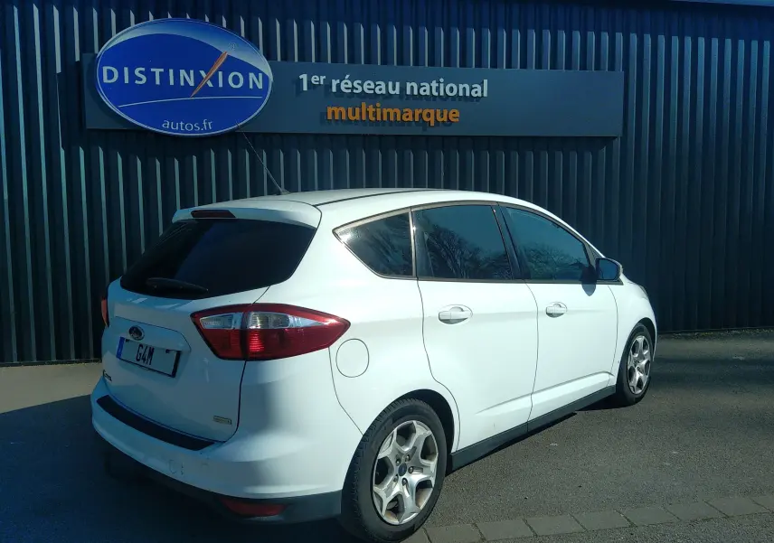 Vue 3/4 arrière droite d'une Ford C-MAX blanche de 2013, avec vitres teintées et jantes alliage visibles.