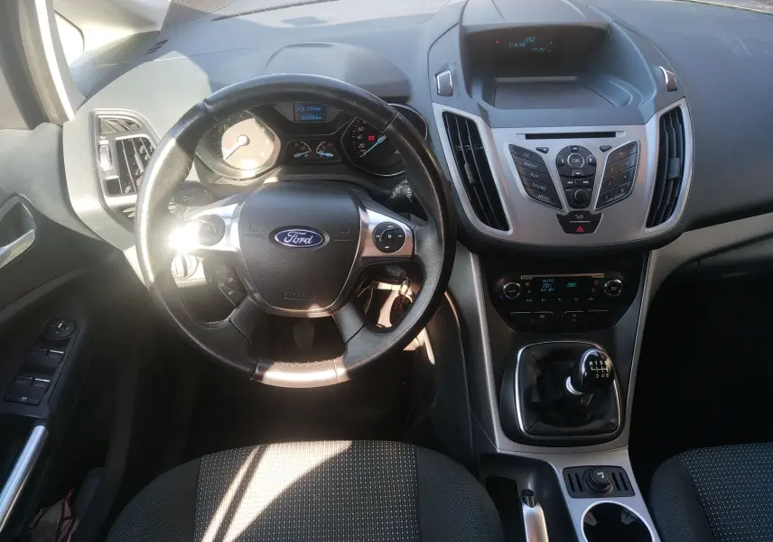 Vue intérieure centrée sur le volant et la console centrale d'une Ford C-MAX 2013 avec levier de vitesses manuel.
