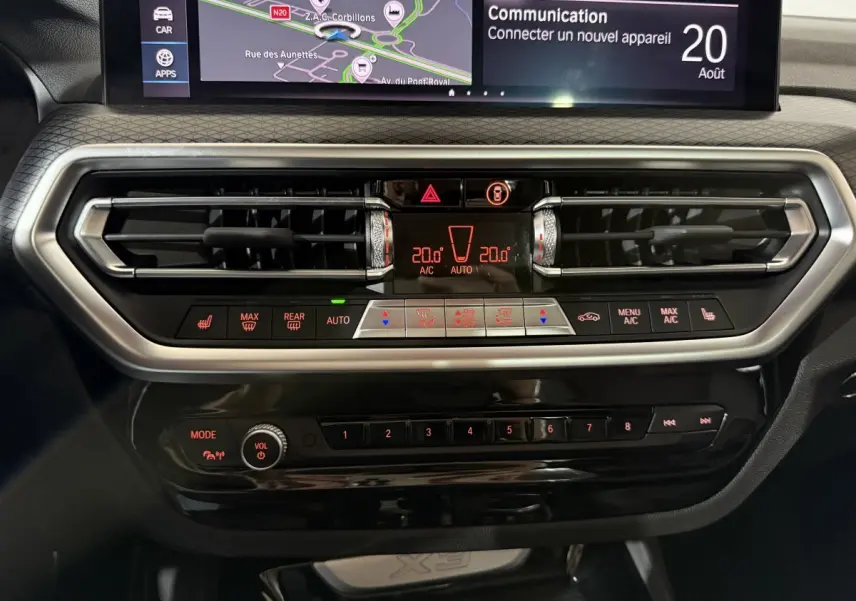 Tableau de bord central du BMW X3 xDrive30e 2023 avec écran tactile et commandes climatisation en vue frontale rapprochée.