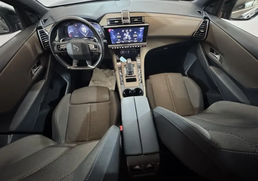 Vue intérieure avant du DS7 Crossback gris foncé, mettant en valeur le tableau de bord digital et l'écran tactile central.