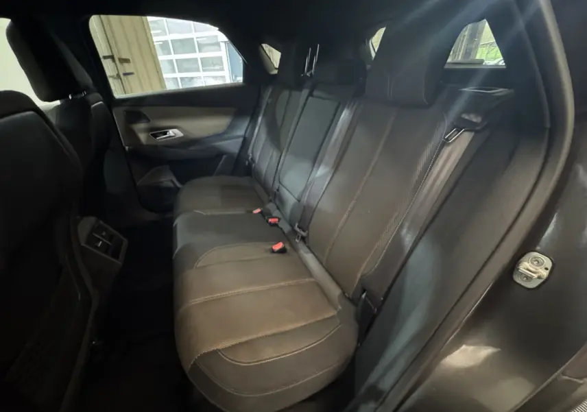Vue intérieure arrière côté droit du DS7 Crossback gris foncé, montrant la banquette en cuir et les ceintures de sécurité.