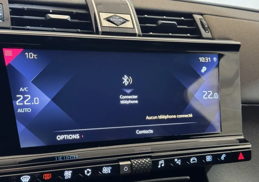 Vue rapprochée de l'écran tactile central du DS7 Crossback gris foncé, affichant la connexion Bluetooth et la climatisation à 22°C.