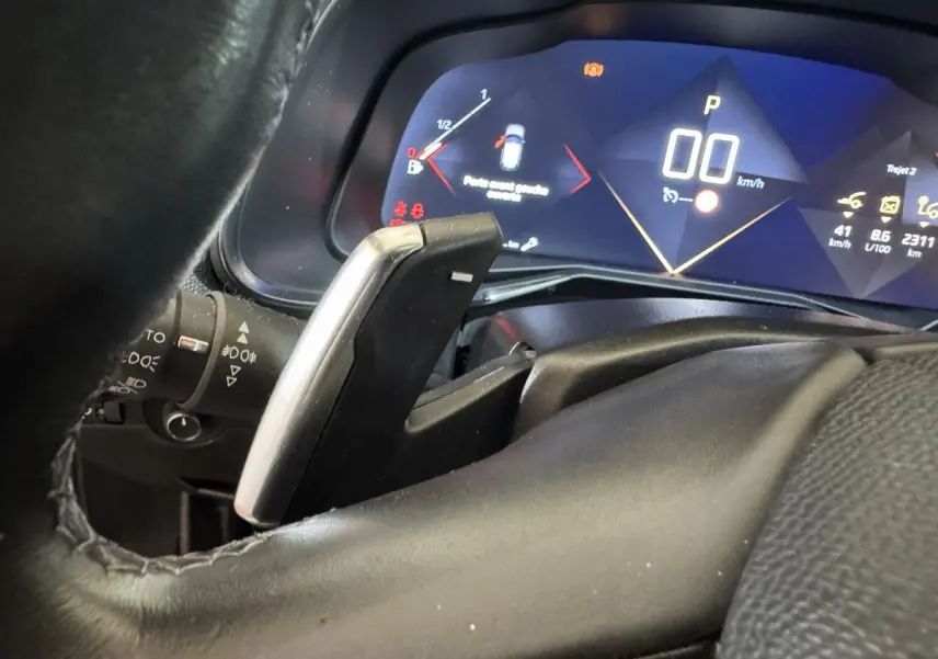 Gros plan sur le levier de vitesse et le tableau de bord numérique bleu du DS7 Crossback PureTech 130.