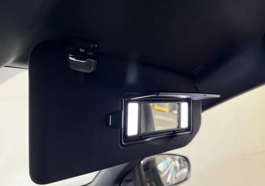 Détail du miroir de courtoisie éclairé sur le pare-soleil côté conducteur du DS7 Crossback gris foncé, intérieur visible.