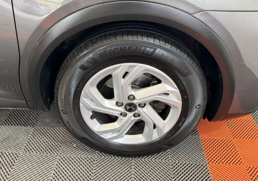 Gros plan sur la roue avant gauche du DS7 Crossback gris foncé, mettant en valeur la jante alliage et le pneu Michelin.