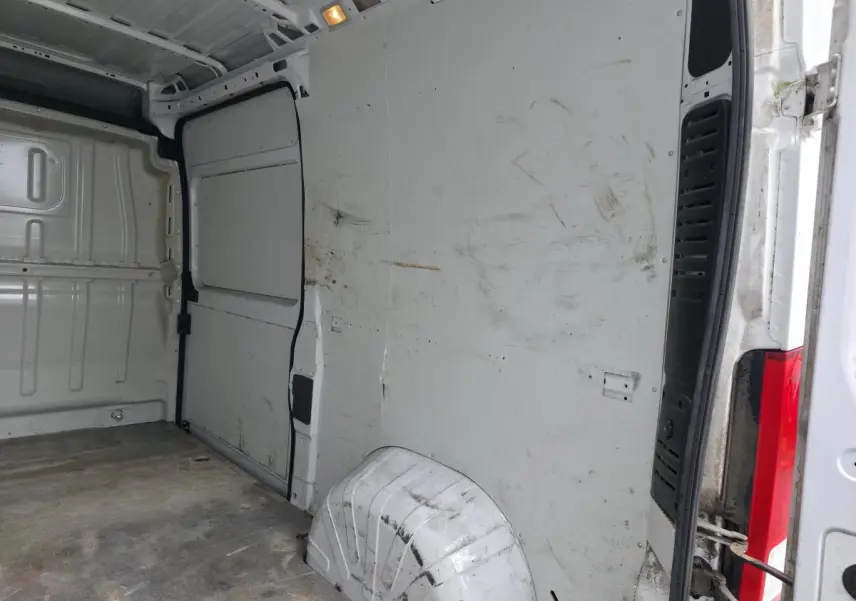 Intérieur de la cellule de chargement du Peugeot Boxer Fourgon blanc, vue côté droit avec cloison tôlée et traces d'usure.