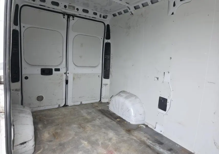 Vue intérieure de la cellule de chargement blanche du Peugeot Boxer Fourgon Asphalt 335 L2H2, montrant les portes arrière ouvertes.