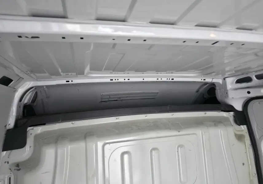 Vue intérieure de la cloison de séparation tôlée blanche du Peugeot Boxer Fourgon, version Asphalt 335 L2H2 2022.