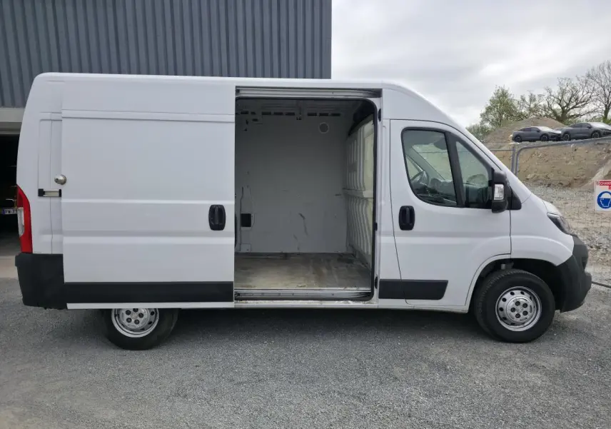 Vue latérale droite d'un Peugeot Boxer Fourgon blanc avec porte coulissante ouverte montrant la cellule de chargement vide.