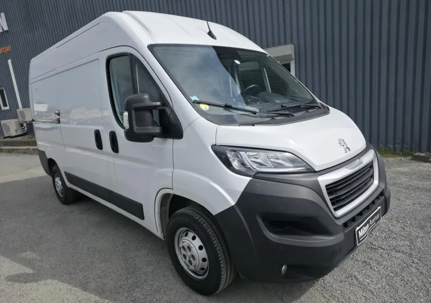 Peugeot Boxer Fourgon blanc vu en 3/4 avant droit avec pare-chocs noirs et rétroviseurs larges.