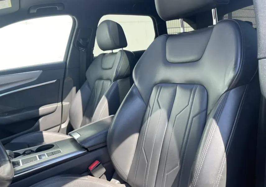 Vue intérieure côté avant droit montrant les sièges en cuir noir et l'accoudoir central de l'Audi A6 V Avant 2019.