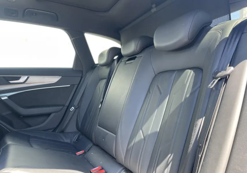 Vue intérieure de la banquette arrière en cuir noir de l'Audi A6 V Avant 2019, avec appuie-têtes et ceintures visibles.