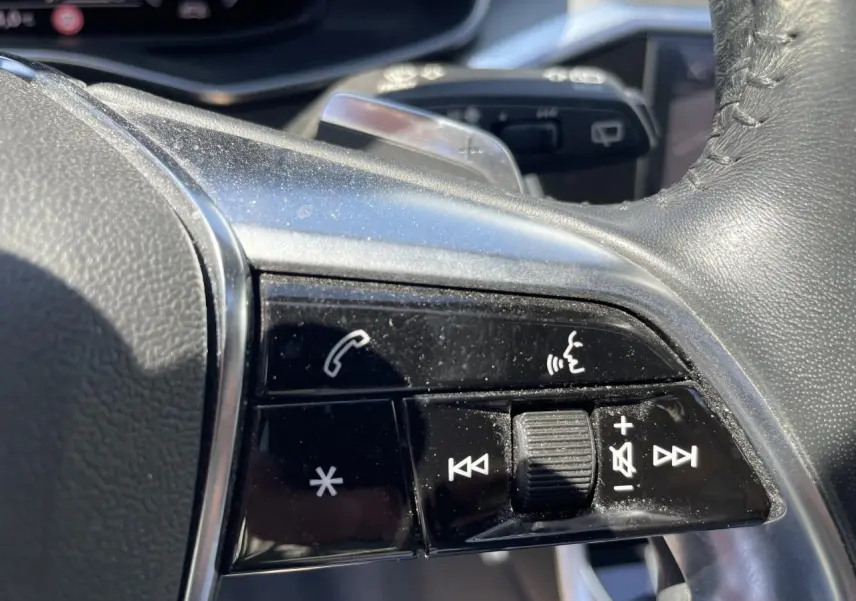 Gros plan sur les commandes multifonctions en cuir noir du volant de l'Audi A6 V Avant 45 TDI 2019.