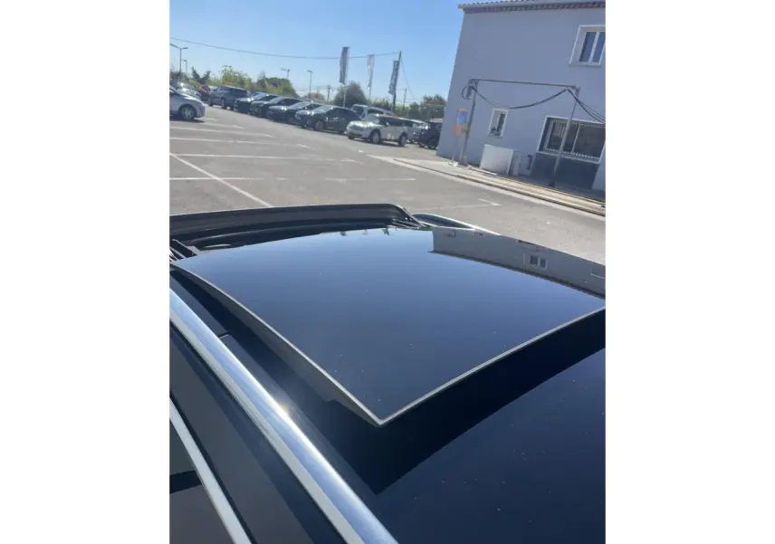 Toit panoramique en verre ouvert sur Audi A6 noir métal, vue en plongée depuis l'arrière droit du véhicule.