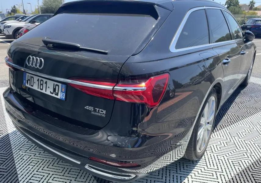 Vue 3/4 arrière droite d'une Audi A6 Avant noire métal avec feux LED et jantes aluminium 19 pouces.