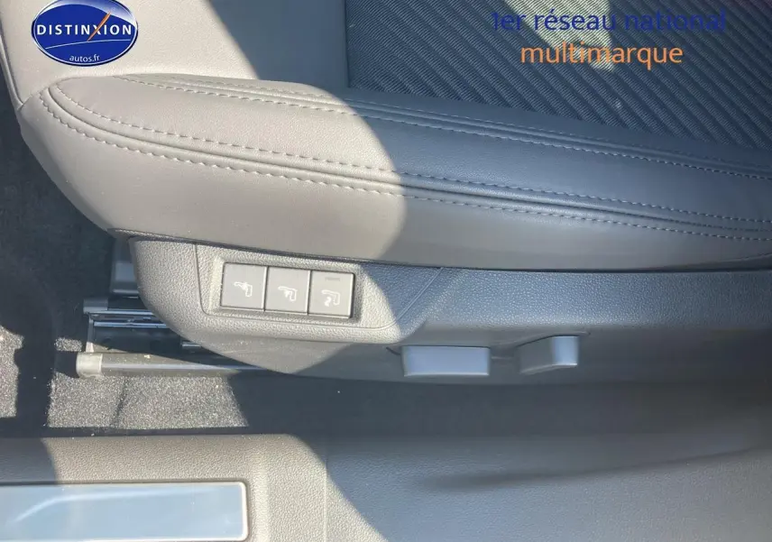 Gros plan sur le siège conducteur gris clair de l'Alfa Romeo Junior 1.2 hybride, avec commandes électriques visibles.