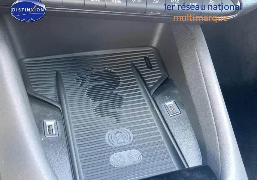 Détail du chargeur à induction noir avec logo serpent Alfa Romeo dans l'habitacle de l'Alfa Romeo Junior 1.2 hybride.