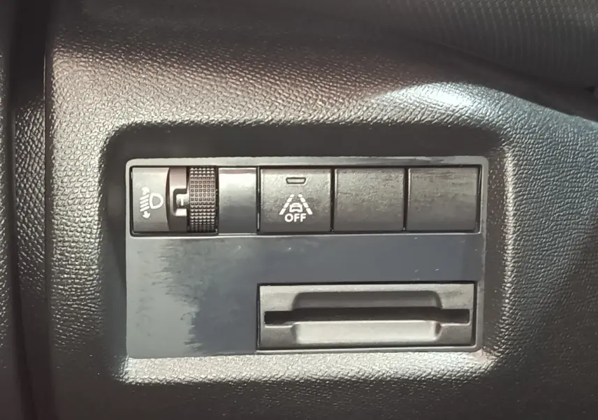 Détail intérieur du tableau de bord noir du Citroën C5 Aircross 2024 avec commandes d'éclairage et d'aide à la conduite.