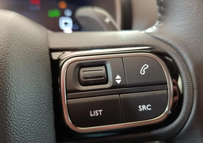 Gros plan sur les commandes multifonctions du volant cuir du Citroën C5 Aircross 2024, finition BlueHDi noir.